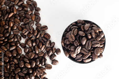 Coffee Beans on white background. close up. Coffee grounds. Freshly roasted coffee beans. Image of a drink made from granules, derived from coffee plant. Copy space for text.