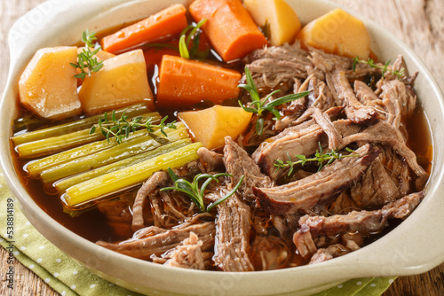Beef meat and vegetables stew Homemade Slow Cooker Pot Roast with Carrots, celery and Potatoes close up in the bowl on the wooden table. Horizontal photo