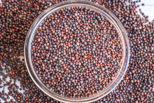 Mustard seeds (Brassica nigra) in a glass bowl close up, top view