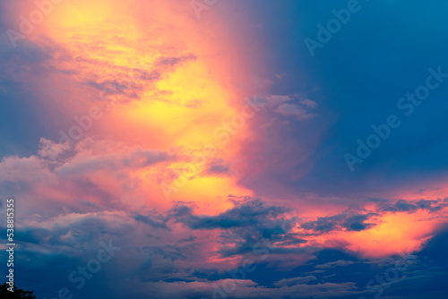 Orange, yellow, pink, purple, blue colors play on the cloudy city sky at sunset