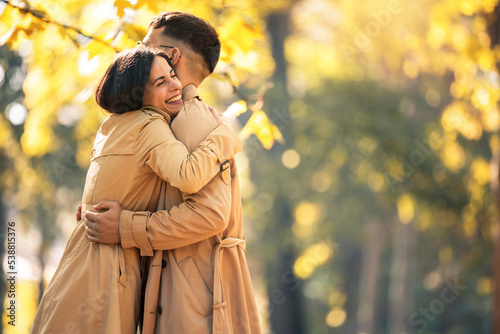 Couple in love hugging on autumn park, enjoying a beautiful autumn day.