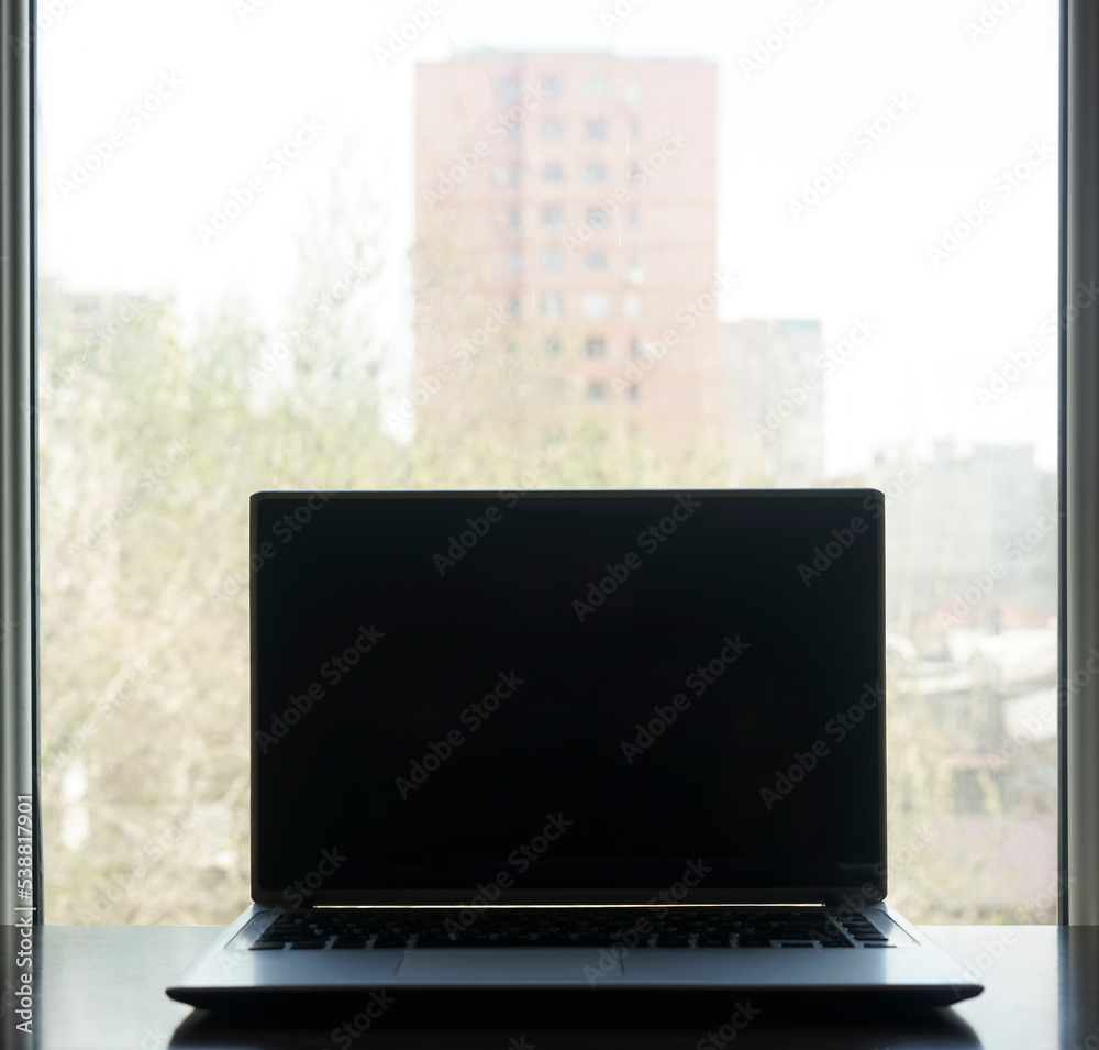 Workplace desk office at home. Blank black laptop screen on wooden table. mock up. Blank empty screen of laptop in cafe at window. Workplace desk office at home. Blank black laptop screen on wooden table. mock up. Blank empty screen of laptop in cafe at window.