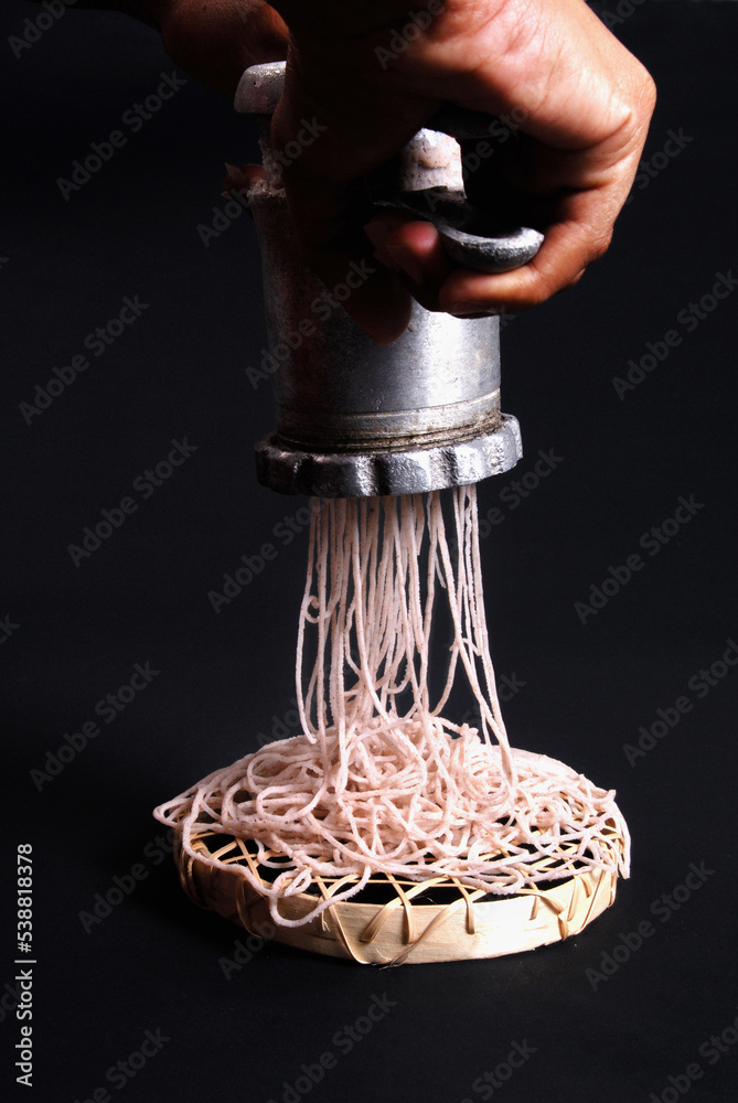 Lady making string hoppers using traditional equipment and flour. sri ...