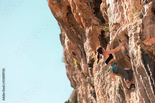 the girl is engaged in rock climbing. sports in nature.