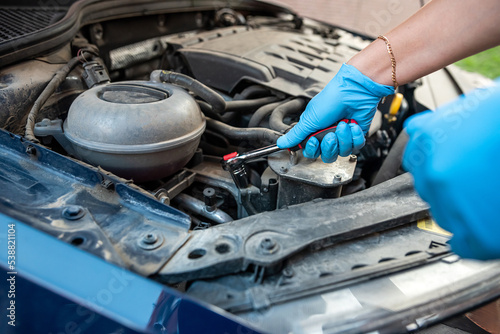 Car maintenance and service close-up technician auto mechanic repairs car engine.