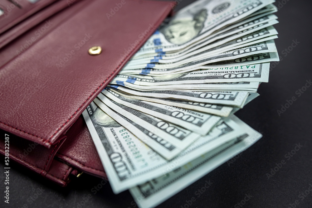 brown leather wallet with what appears to be US dollar money inside. brown leather wallet with what appears to be US dollar money inside.