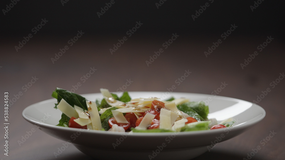making salad pour dressing over in white bowl making salad pour dressing over in white bowl