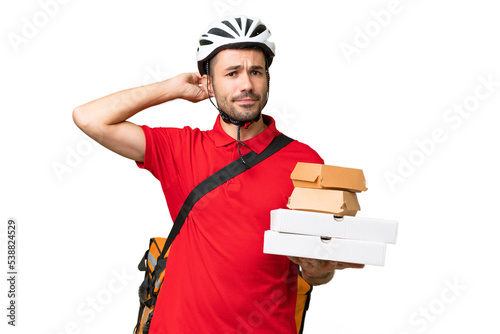 Young handsome caucasian man with thermal backpack and holding takeaway food over isolated background having doubts