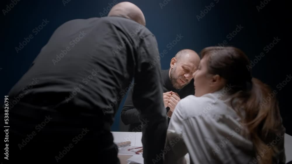 Police detective abruptly stands up, slams fist on table and shouts at suspected man in handcuffs. Interrogation of criminal. Murderer is afraid of FBI agent's threats and is ready to tell everything Police detective abruptly stands up, slams fist on table and shouts at suspected man in handcuffs. Interrogation of criminal. Murderer is afraid of FBI agent's threats and is ready to tell everything
