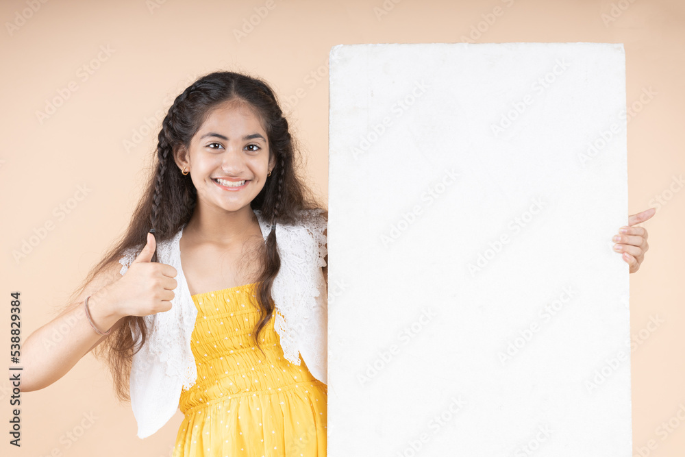 Young girl holding a blank board with thumbs up Young girl holding a blank board with thumbs up