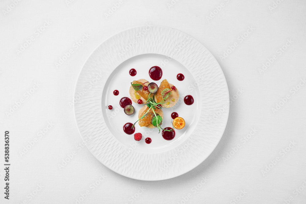 Foie gras with apple confit and berry sauce in a white plate on a white background. Close-up, selective focus. - obrazy, fototapety, plakaty 
