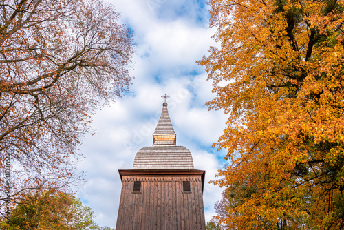 The tower of the historic church made of wood. The church is covered with shingles. Autumn. Polanka Wielka, Poland