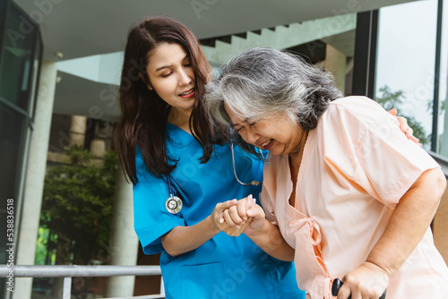 Female doctor attending to help elderly grandmother who is sick worried expression on her face helping senior patient walk to check the condition medical examination and sympathize with the patient.