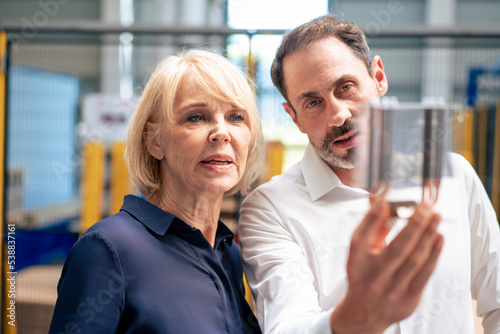 Businessman with senior businesswoman analyzing heating module in industry