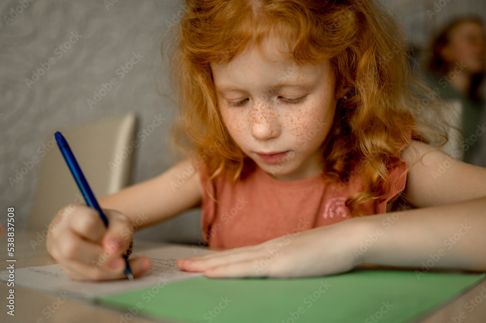 Redhead girl drawing with color pencil at home Redhead girl drawing with color pencil at home