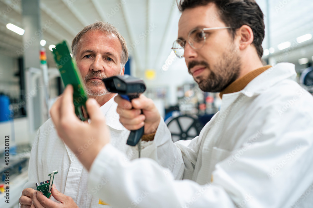 Engineer scanning circuit board with bar code scanner in industry Engineer scanning circuit board with bar code scanner in industry