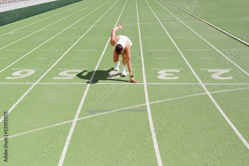 Athlete getting ready to start running on track