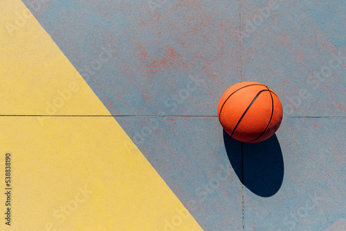 Basketball in sports court on sunny day photo