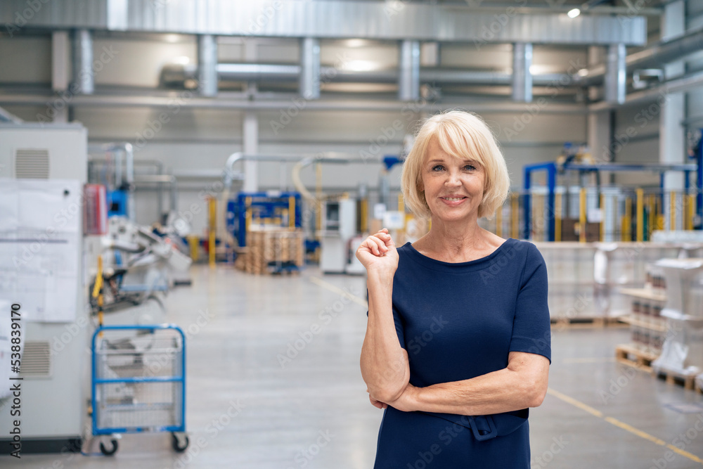 Smiling senior businesswoman with blond hair in industry Smiling senior businesswoman with blond hair in industry