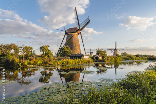 Netherlands, South Holland, Kinderdijk, Countryside river and historic windmills photo