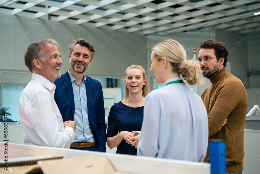 Happy business colleagues having discussion with each other at industry
