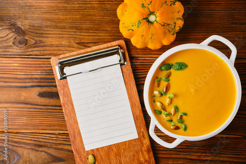 Homemade pumpkin soup with cream in a white bouillon dish
