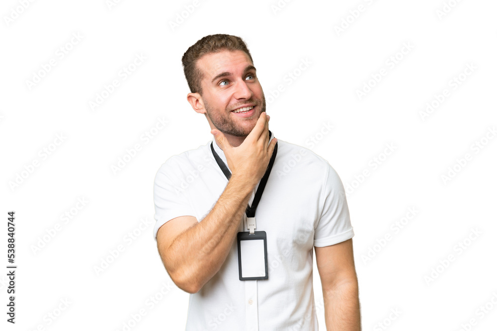 Young caucasian man with ID card isolated on green chroma background looking up while smiling Young caucasian man with ID card isolated on green chroma background looking up while smiling