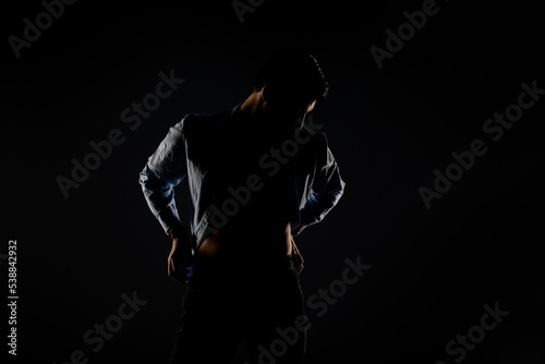 Male model posing in a light dimmed room © qunica.com