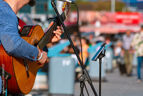 Canvas Print Street performer man playing guitar in the square in focus