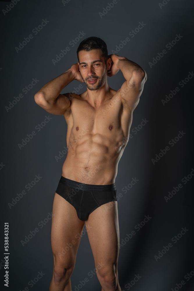 Fashion close-up portrait of a handsome male with bare torso posing in black underwear on isolated background Fashion close-up portrait of a handsome male with bare torso posing in black underwear on isolated background