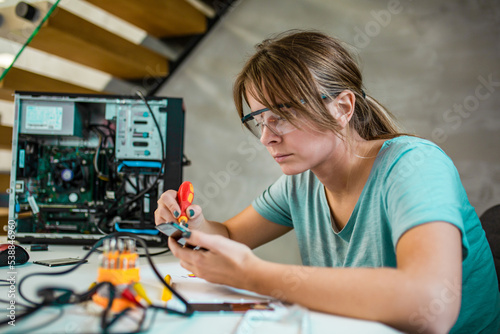 Portrait of a yoing woman repairing desktop computer
Woman wearing protective glasses