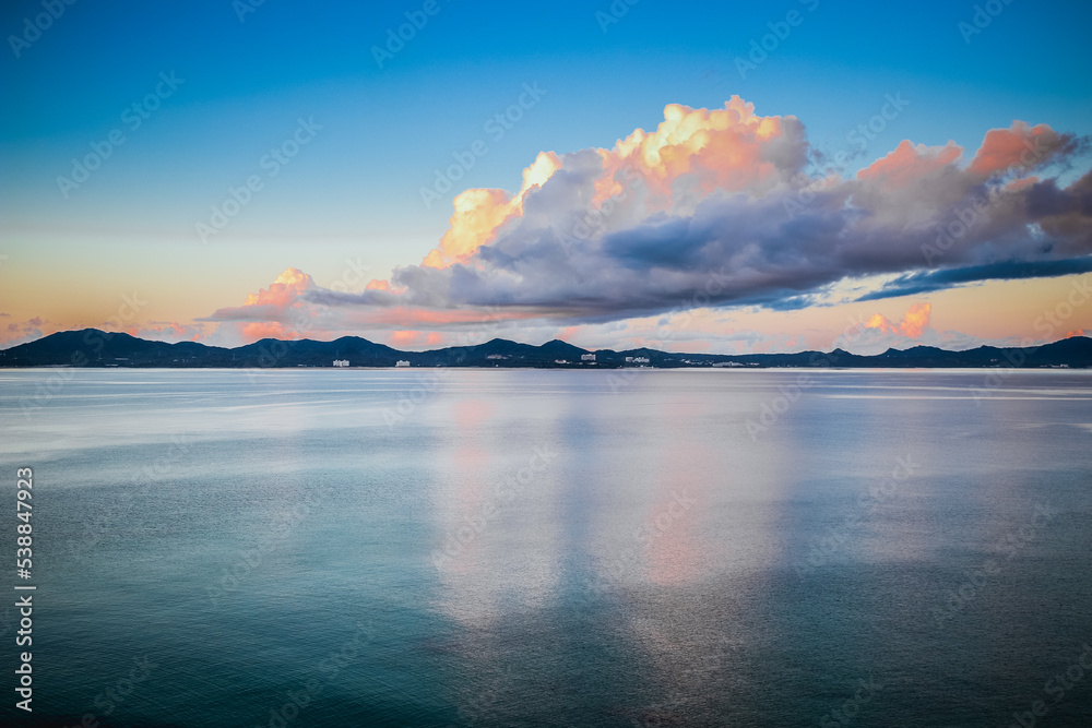 Early sunrise In August, Japan, Okinawa, Nago Clouds are reflected in the surface of the sea