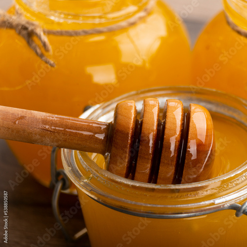 Honey on wooden honey-dipper closeup food background