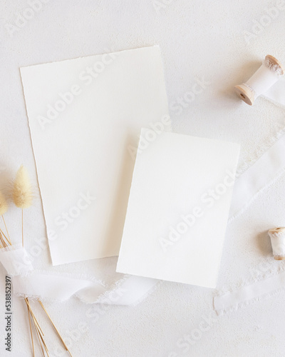 Blank cards near silk ribbons and dried hare's tail grass top view on white, boho mockup