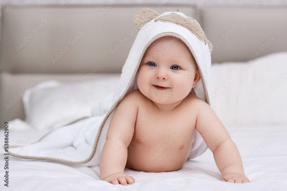 adorable baby girl lies on a white bed with a towel adorable baby girl lies on a white bed with a towel