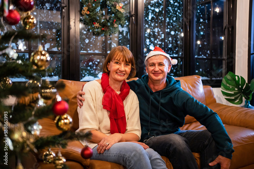 Portrait of senior elderly couple celebrate Christmas party in house. 