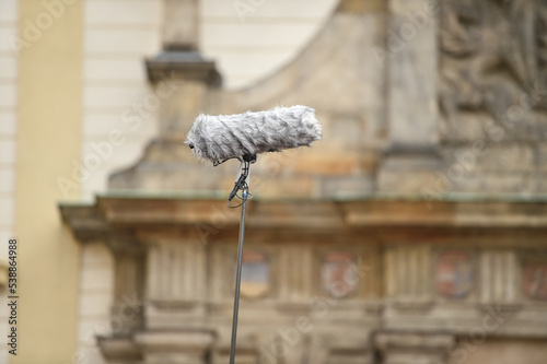Hand hold press boom microphone with old building on background photo