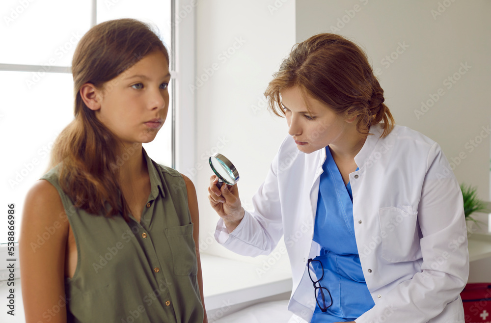 Professional dermatologist examines child patient. Female doctor in
