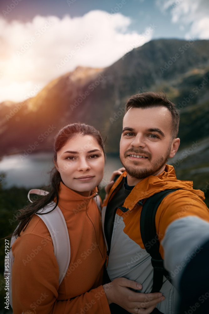Happy couple hiking. Young couple man and woman in the mountains smiling.