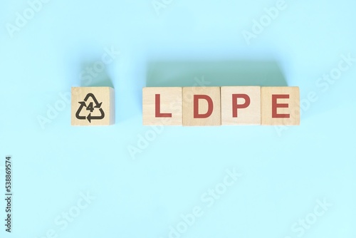 Recycling icon number 4 for LDPE or Low Density Polyethylene symbol on wooden blocks flat lay. photo