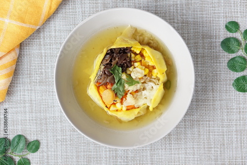 Sop Matahari is a dish from Surakarta, Central Java. This soup made from mushroom, chicken chop, carrot, corn,celery and then wrapped by fried egg added chicken stock and fried onion. photo