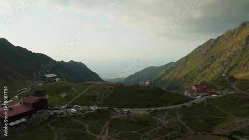  Aerial view from the top of lake Balea, at the end of Transfagaran road in the Fagaras mountains, Romania.The lake is surrounded by mountains, including Moldoveanu, the highest peak in Romania. photo