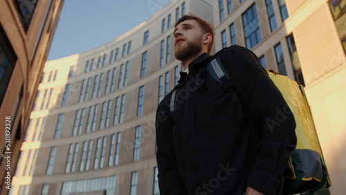 Wallpaper Mural Portrait of a courier who got lost in the area of office buildings and looks at the map on the phone. Express food delivery of their restaurants Torontodigital.ca