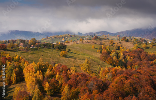Fototapeta Naklejka Na Ścianę i Meble -  Autumn landscape in Romania. Beautiful sightseeing with the fall landscape from villages of Rucar Bran passage in Transylvania with old houses and folk scenery views. Wide angle view.
