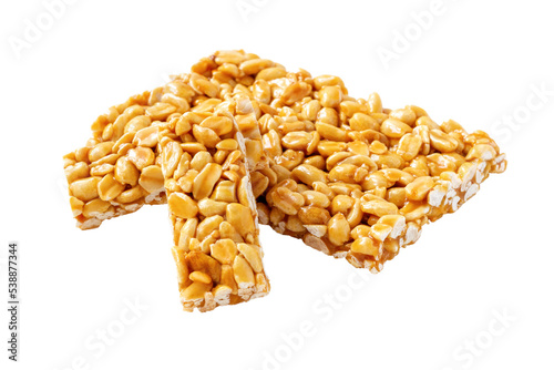 Brittle peanut chikki isolated on white background. Caramelized groundnut bars. Nut candy. photo