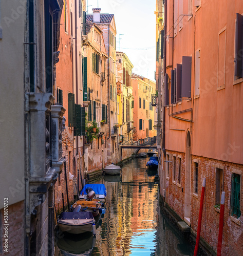 View on the narrow cozy streets of the canals with parked boats in Venice  Italy. Architecture and landmark of Venice.