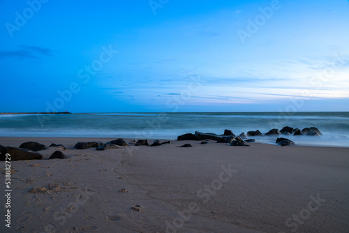 Long exposure by the sea with rocks in the sand, blue hour. Denmark beach