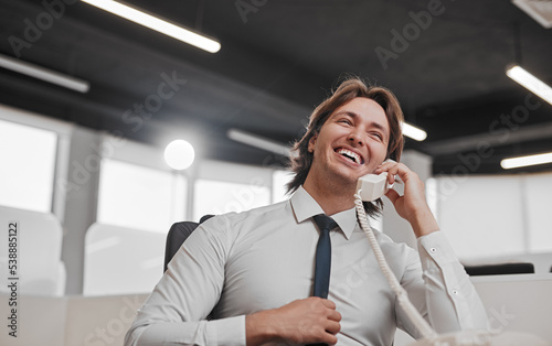 Happy manager speaking on telephone