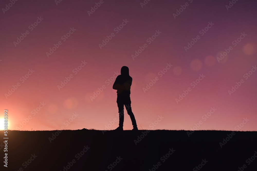 man trekking in the mountain with a sunset background in summertime