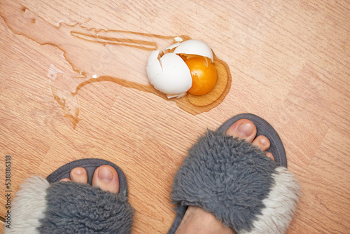 broken egg and feet on the floor in kitchen